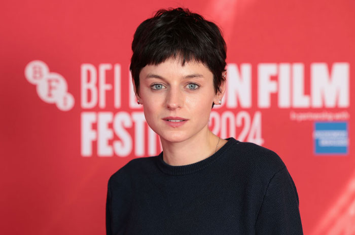 Emma Corrin in front of a BFI London Film Festival backdrop, related to Deadpool cast and cameos.