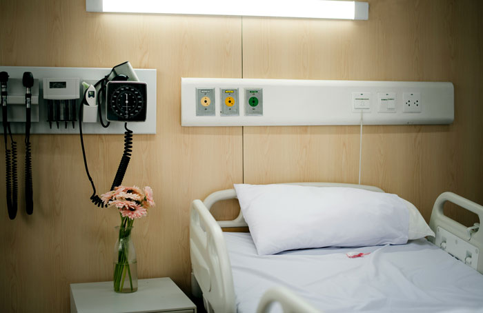 Hospital room with a bed and medical equipment, related to woman traveling to see terminally ill mother.