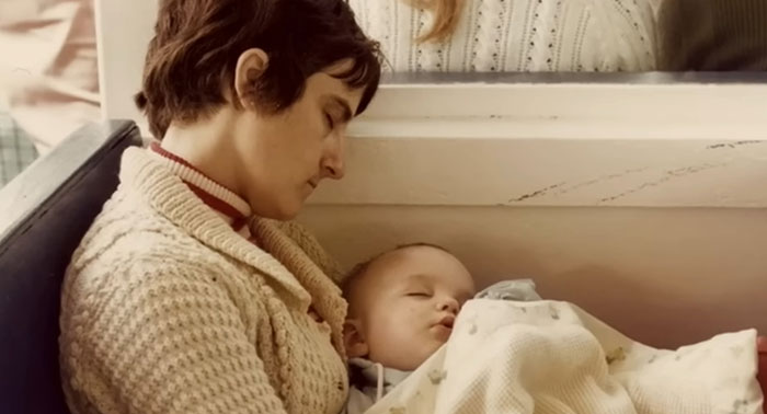 Woman and baby asleep together on a bench, capturing a sad and depressing movie ending moment.