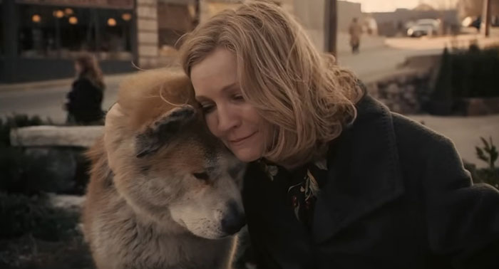 A woman and a dog share a somber moment, reflecting a sad movie ending.