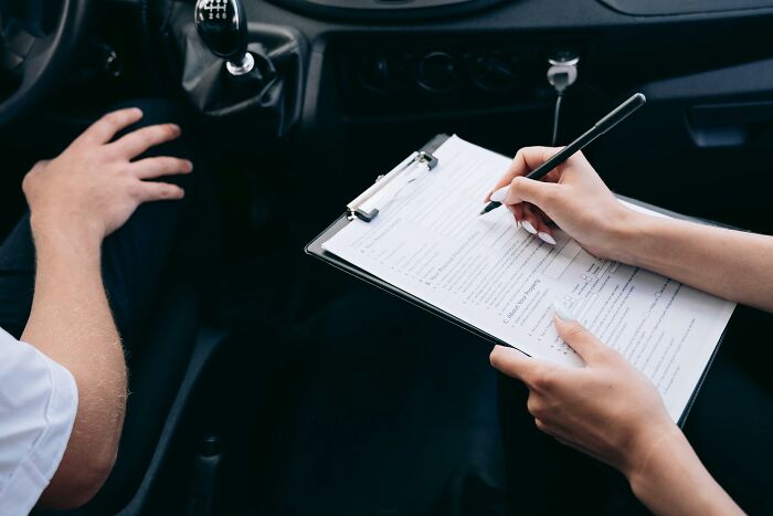 Person signing document in a car.