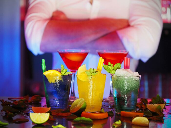 Colorful cocktails at a bar, highlighting luxury expenses no longer affordable to many due to rising costs.