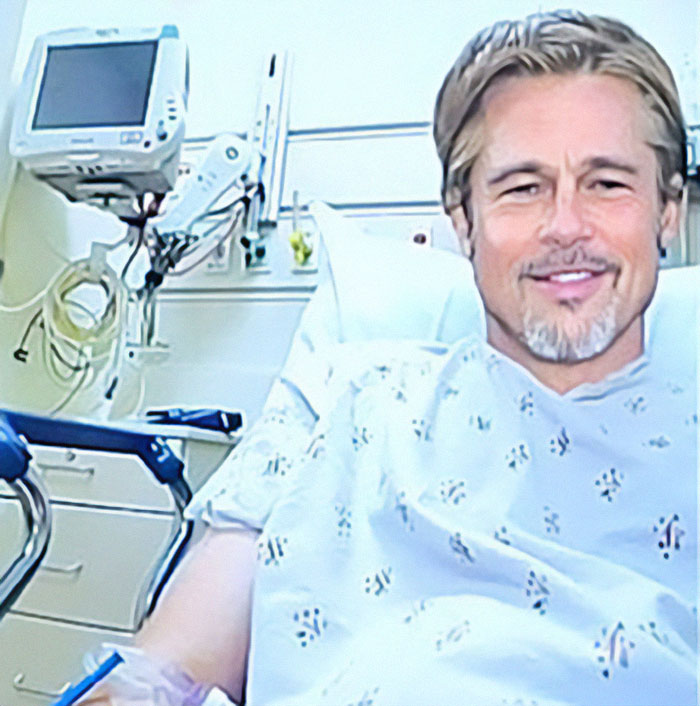 A man in a hospital gown, resembling a celebrity, in a hospital room with medical equipment.