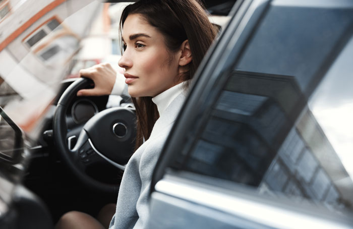 Woman driving a car, reflecting on family New Year's Eve drama.