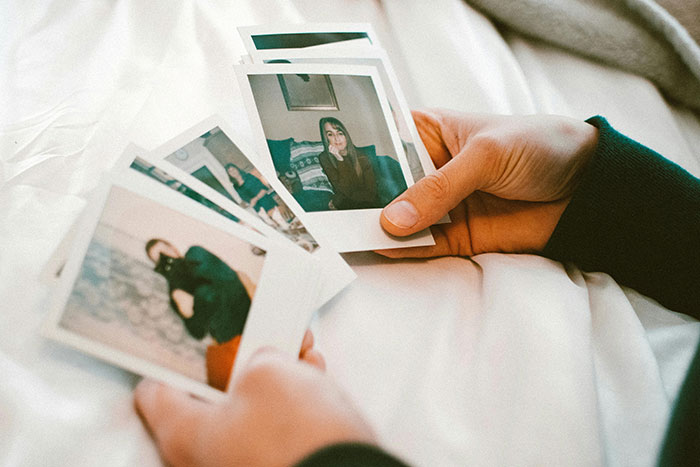 Hands holding photos, relevant to husband's absence from in-laws' anniversary collage.