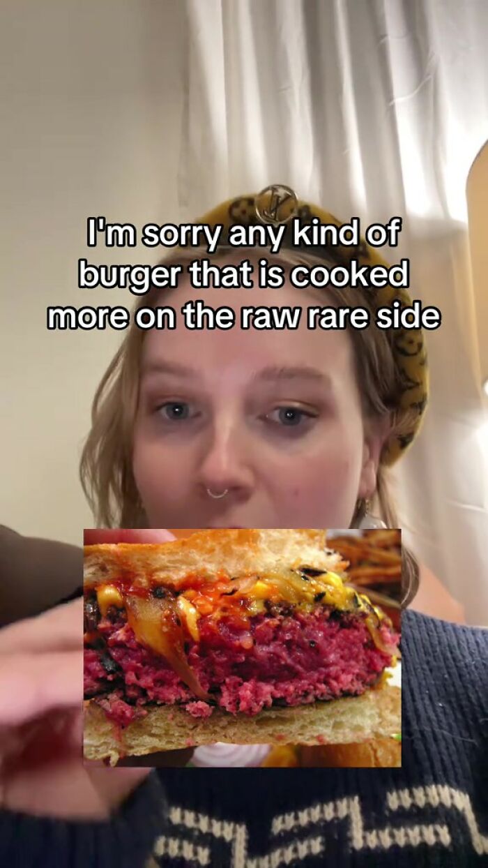 Close-up of a person with a burger, text about raw rare meat; food and bacteria concern.