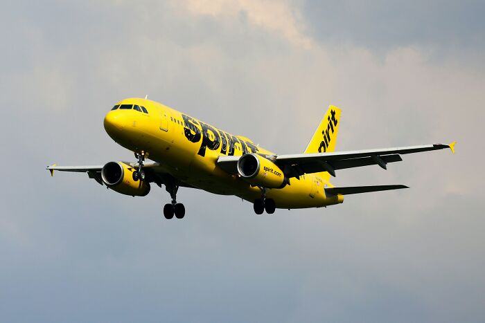 Yellow airplane in flight against a cloudy sky, representing expensive items worth spending money on.