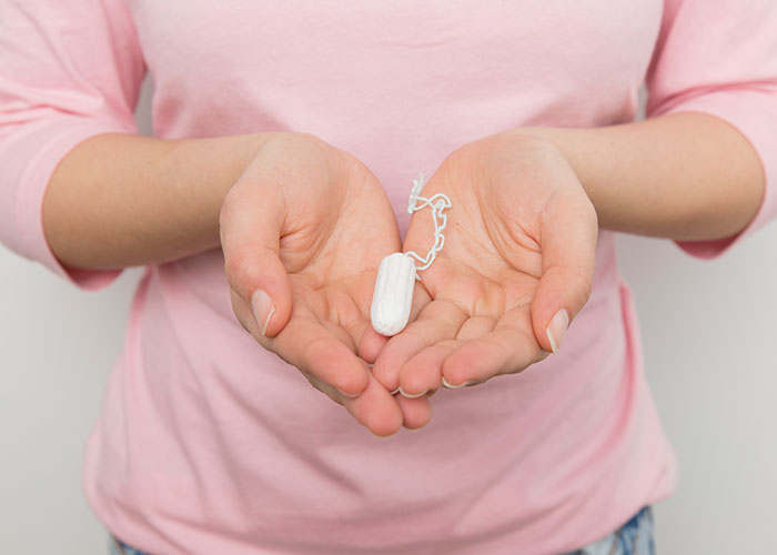 Hands holding a tampon, highlighting a common topic often subject to mansplaining.