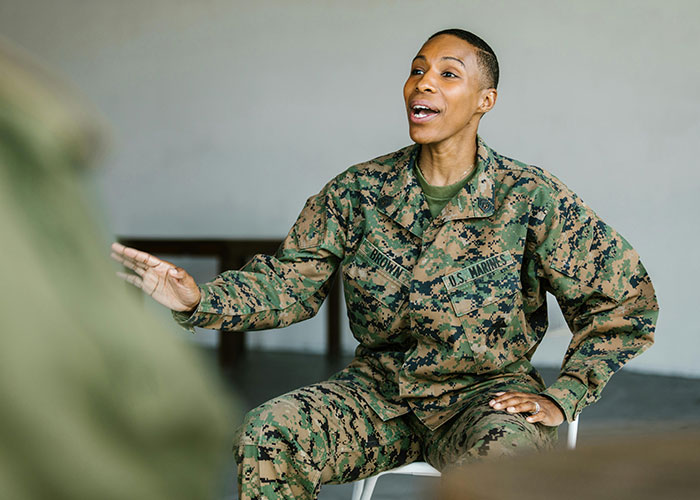 U.S. Marine in uniform gesturing as if explaining, illustrating a concept related to mansplaining topics.