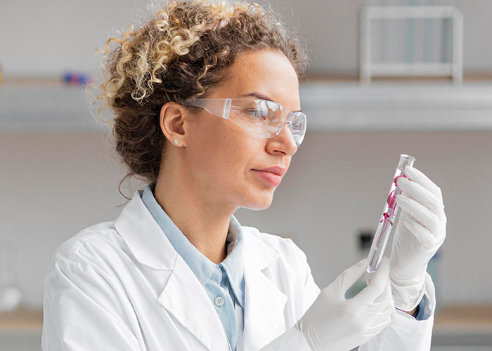 Scientist in a lab coat examining a test tube, embodying knowledge contrasted by mansplaining narratives.