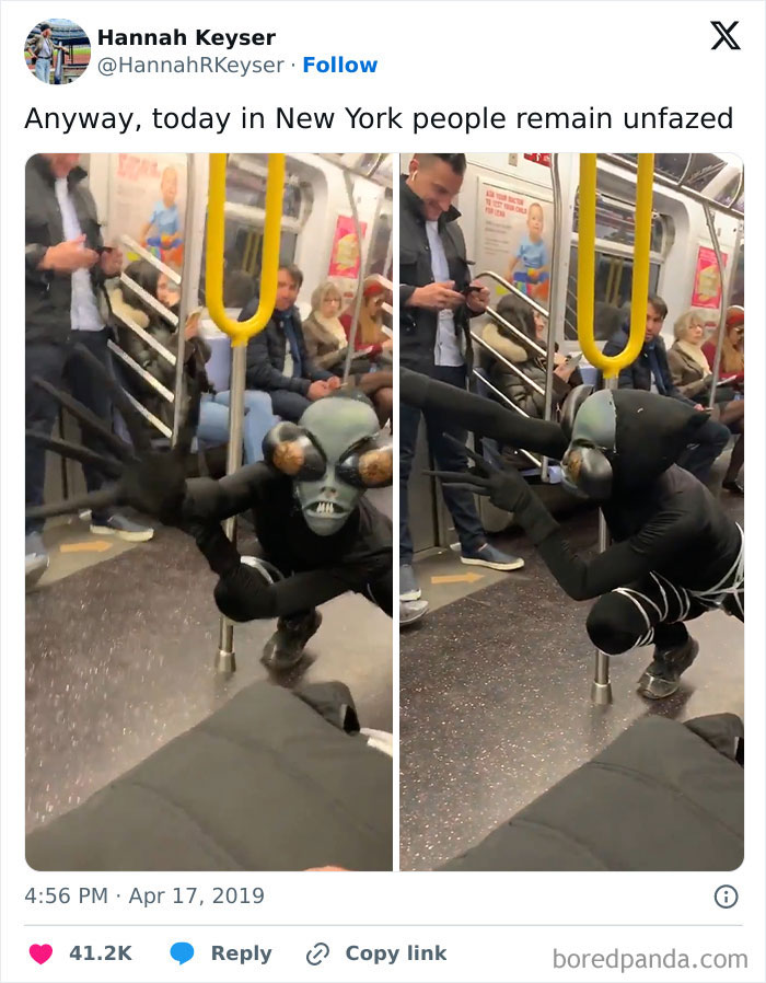 A funny subway passenger in an alien costume crouches on a New York train, while others remain unfazed.