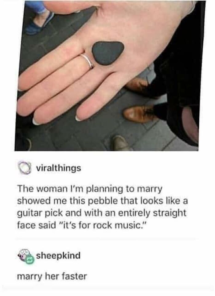 Hand holding pebble shaped like a guitar pick, symbolizing kindness and creativity in a heartwarming moment.