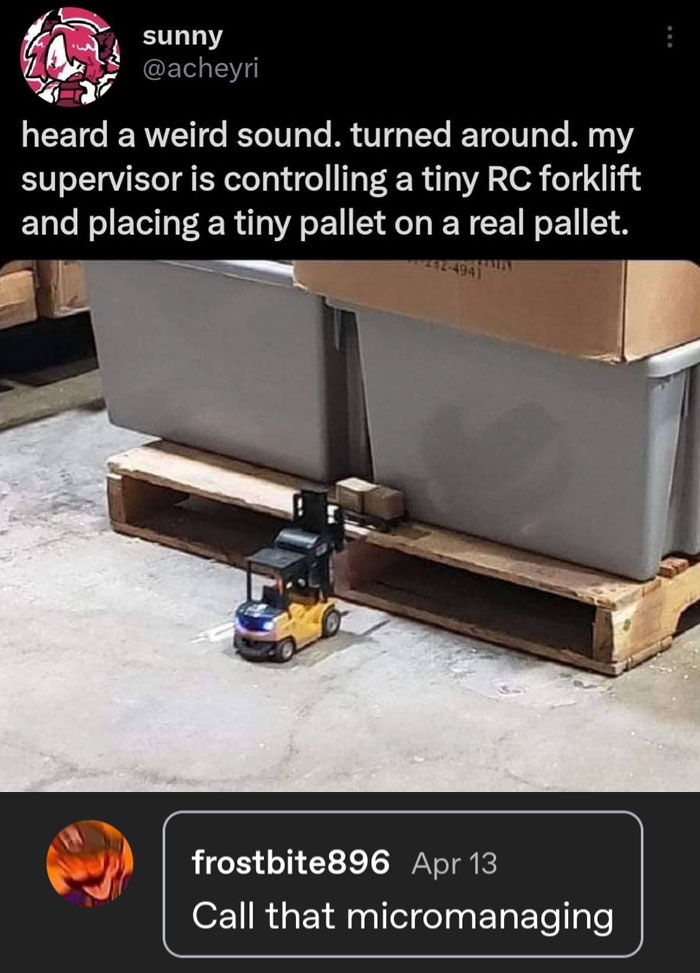 Tiny RC forklift placing a small pallet on a larger one, showcasing a playful moment of kindness in the workplace.