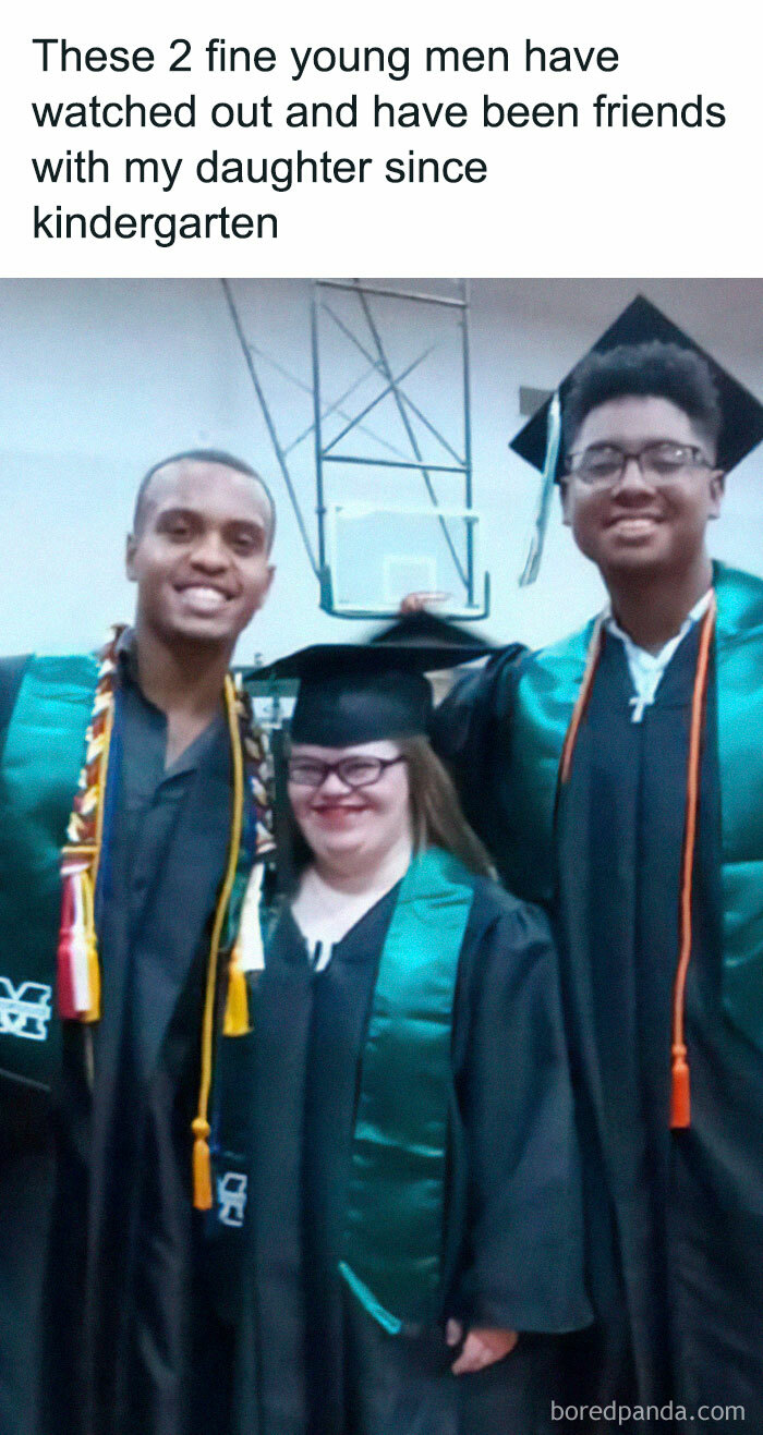 Three graduates celebrate friendship and kindness in caps and gowns, standing together with smiles.