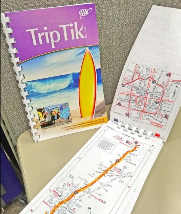 Gen X TripTik map booklet open on a table, featuring a colorful surfboard cover and detailed map pages.