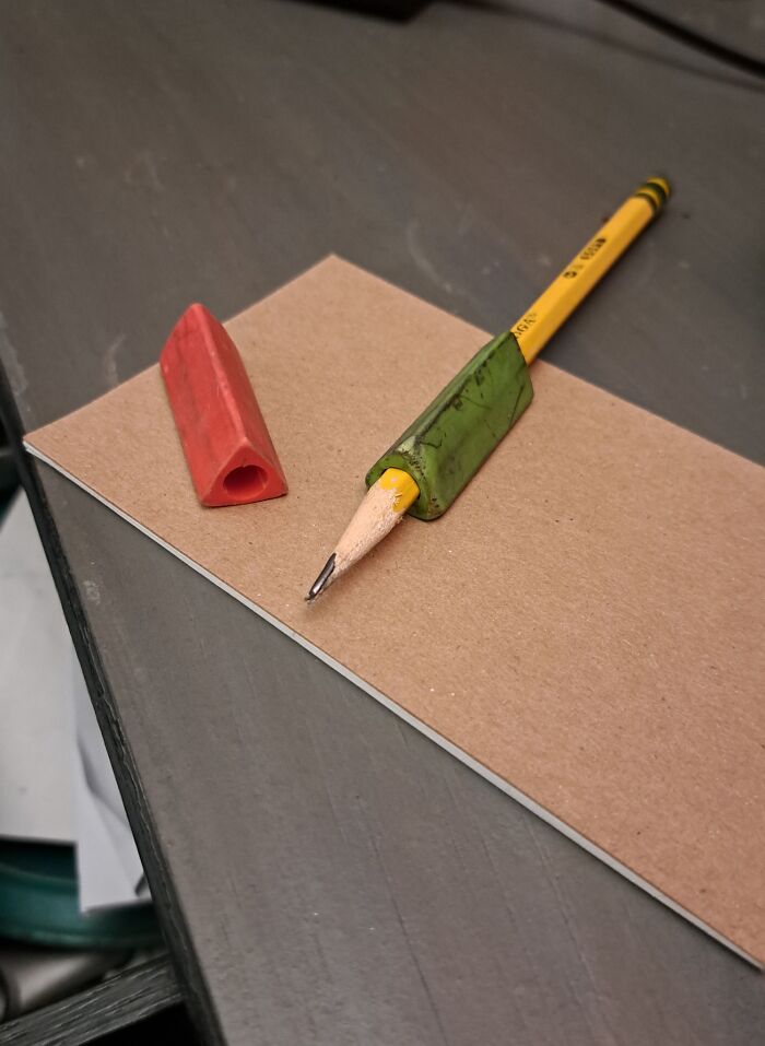 Gen X nostalgia: a worn-down pencil with a green grip and a red eraser on a desk.