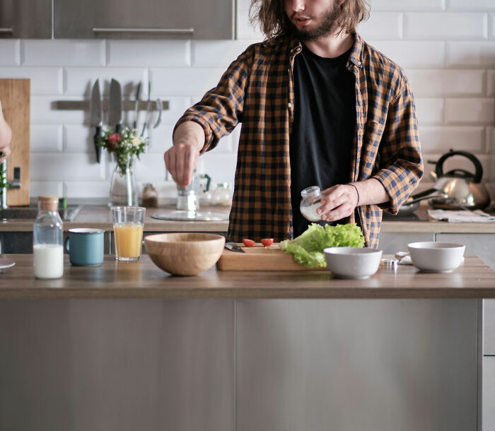 Man preparing a meal in a modern kitchen, showcasing one of the non-sexual things that turn women on.