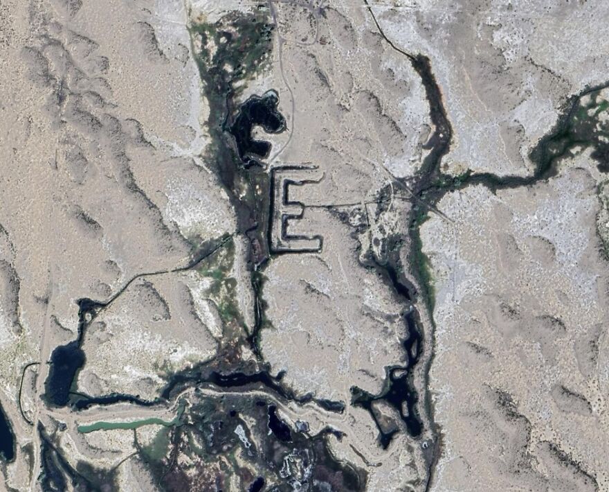 Mysterious large letter E formation in a desert landscape found on Google Earth.