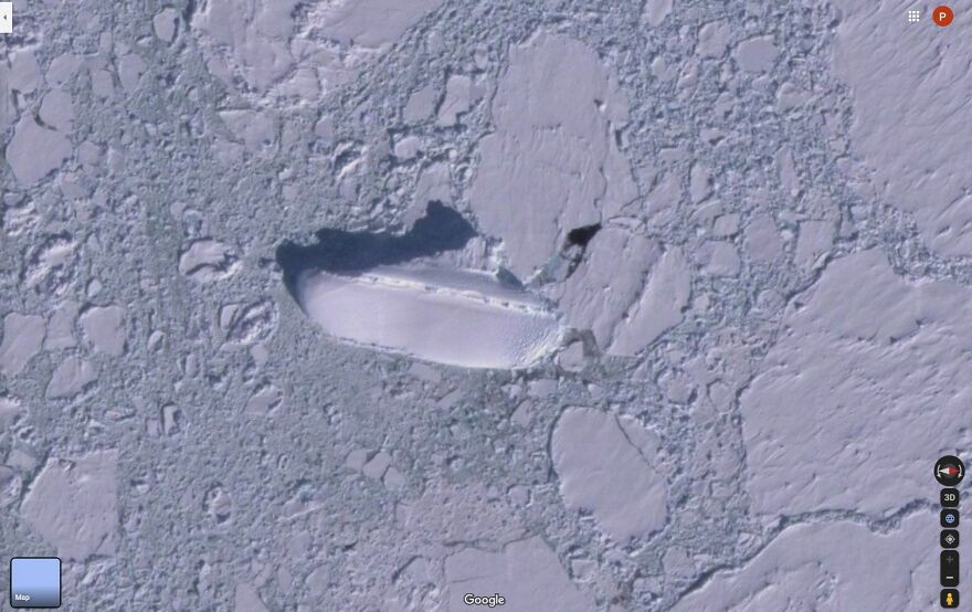 Strange object found on Google Earth resembling a ship, surrounded by cracked ice and snow.