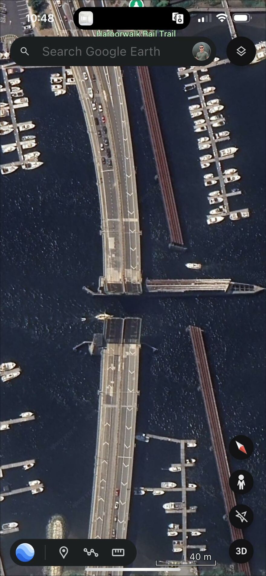 Aerial view of an open drawbridge found on Google Earth, with boats in the surrounding water.