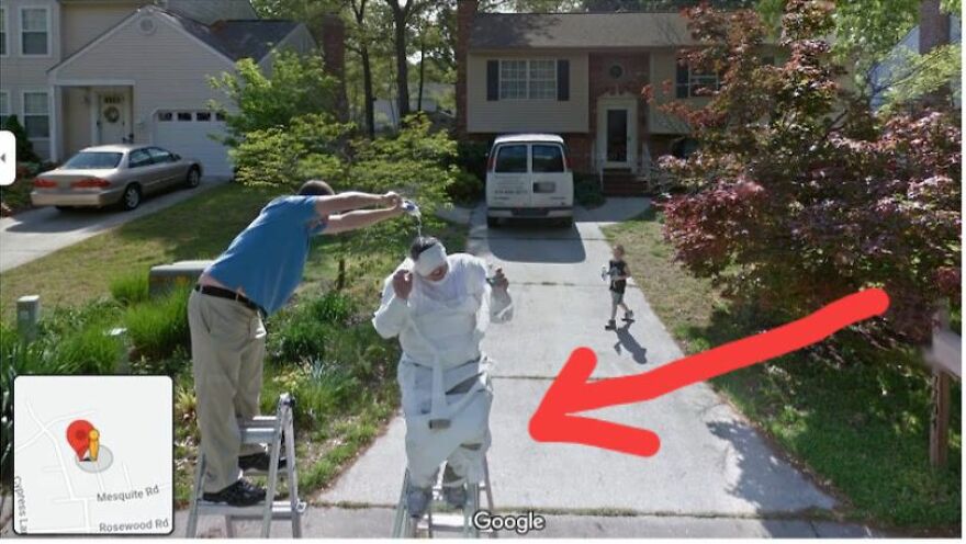 Person in a white suit and helmet on a driveway with red arrow, found on Google Earth, drawing attention to strange sighting.