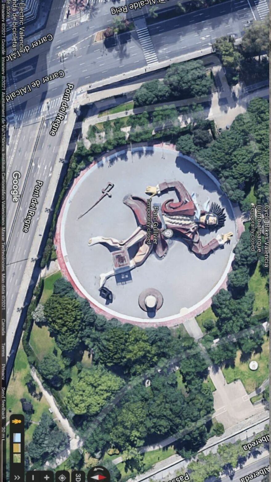 Giant Gulliver figure in a park found on Google Earth, surrounded by trees and roads.