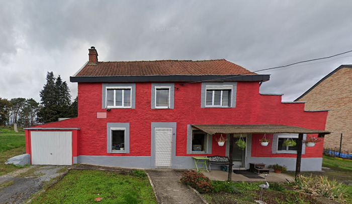 Red house on a cloudy day, central to a mysterious disappearance linked to Google Maps findings after two years.