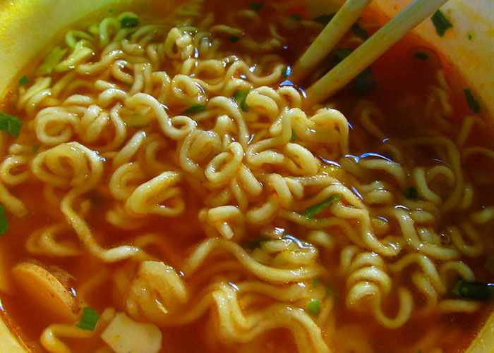 Close-up of instant noodles with chopsticks, a dish enjoyed by wealthy people thinking it was an ordinary meal.