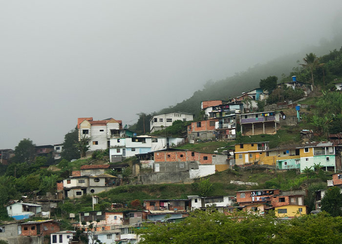 Colorful hillside houses under a misty sky, related to wealthy people's perceptions of ordinary things.