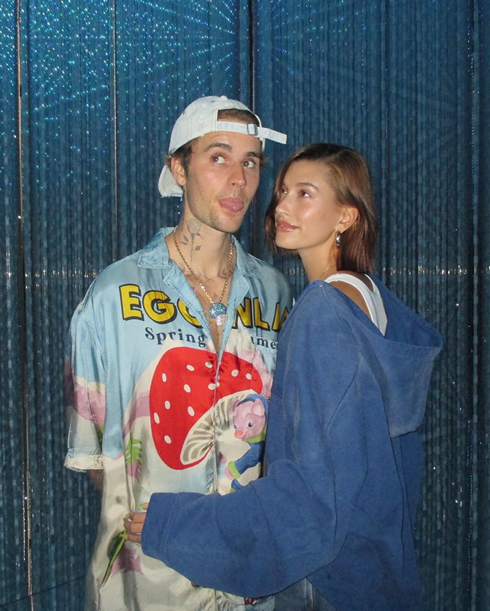 Justin Bieber and Hailey Bieber posing together in casual clothing.