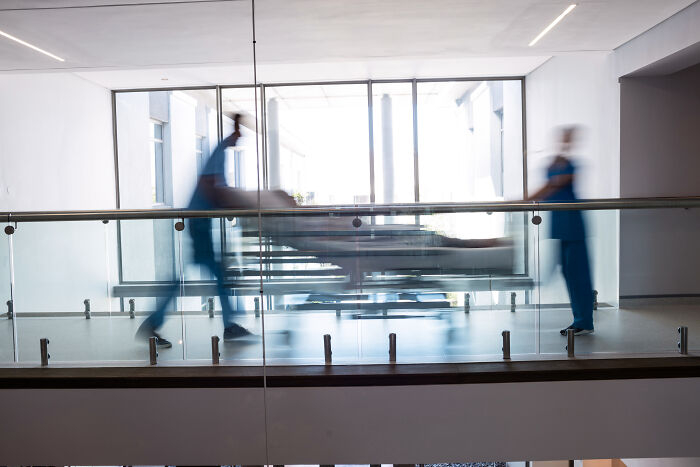 Hospital staff rushing a patient on a gurney in a bright corridor, highlighting Prospect Medical's financial struggles.