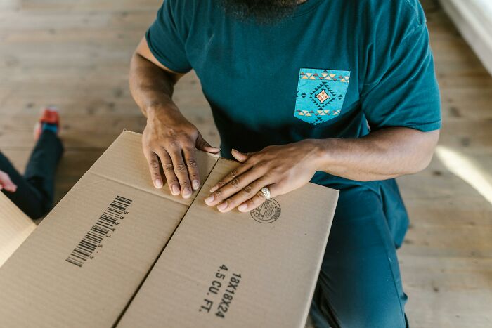 Person packing a box, representing closure of clinics due to Prospect Medical debt issues.