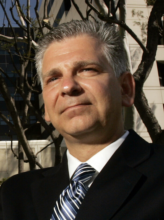 Businessman in formal attire outside a building, related to Prospect Medical's debt situation.