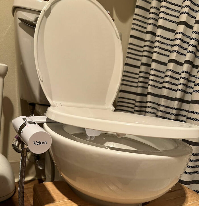 "DIY bidet attachment on a toilet displaying a budget-friendly home hack for bathroom upgrades."