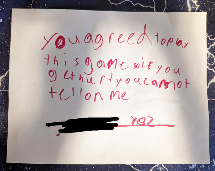 Child's handwritten note on paper, humorously stating game agreement, illustrating kids' logic.