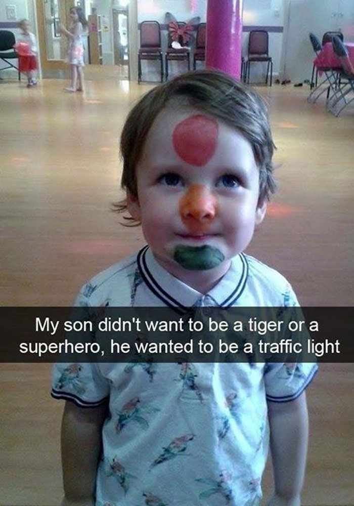 Child with face paint resembling a traffic light, showcasing a humorous moment. Hilarious-Kids.