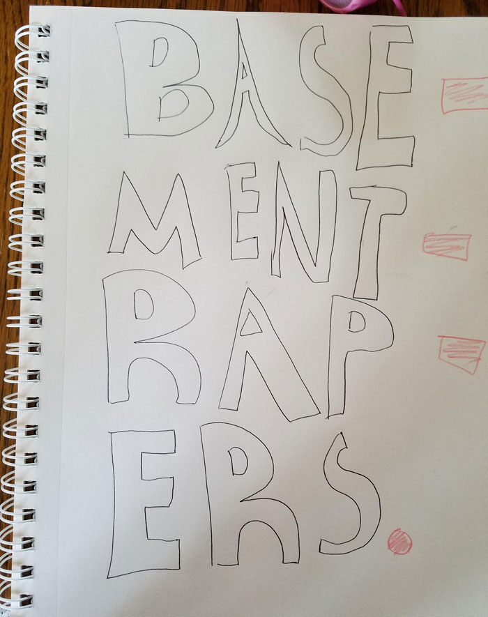 Kid's funny drawing spelling "Basement Rapers" in large letters on a sketchpad.