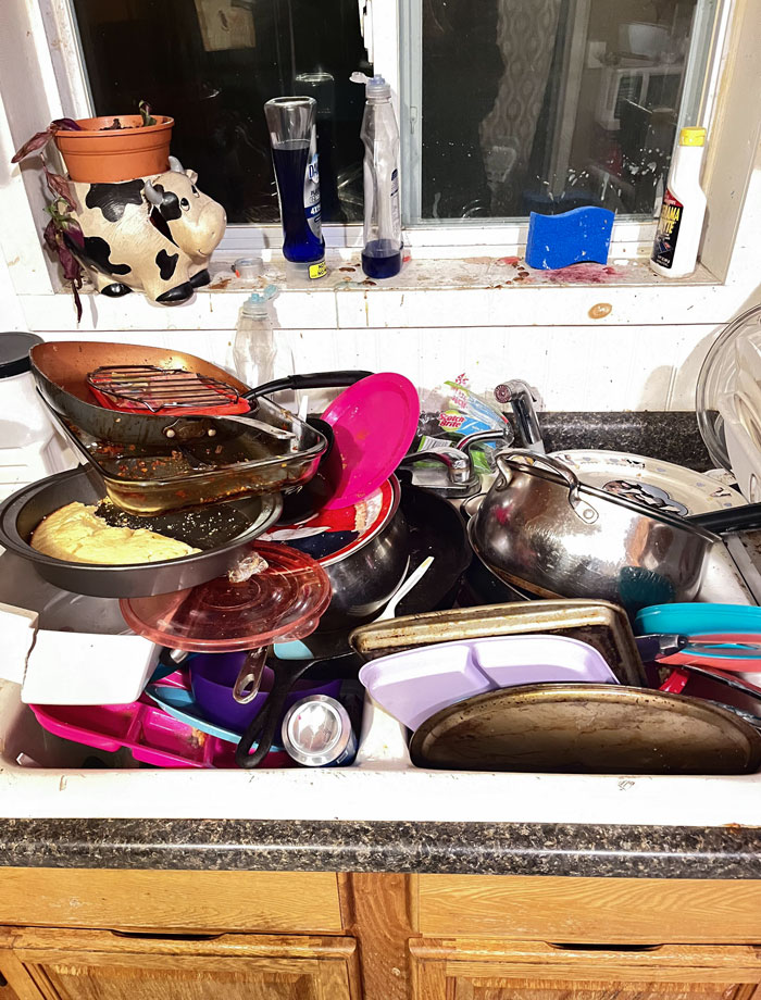 Overflowing sink with dirty dishes and cookware, illustrating horrible roommates' messy habits.