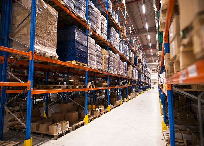 Warehouse aisle with stacked pallets, a normal sight that can feel pretty horrific when overanalyzed.