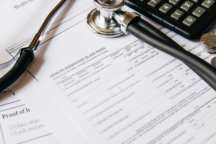 Hospital bill details with a stethoscope and calculator on a medical claim form.