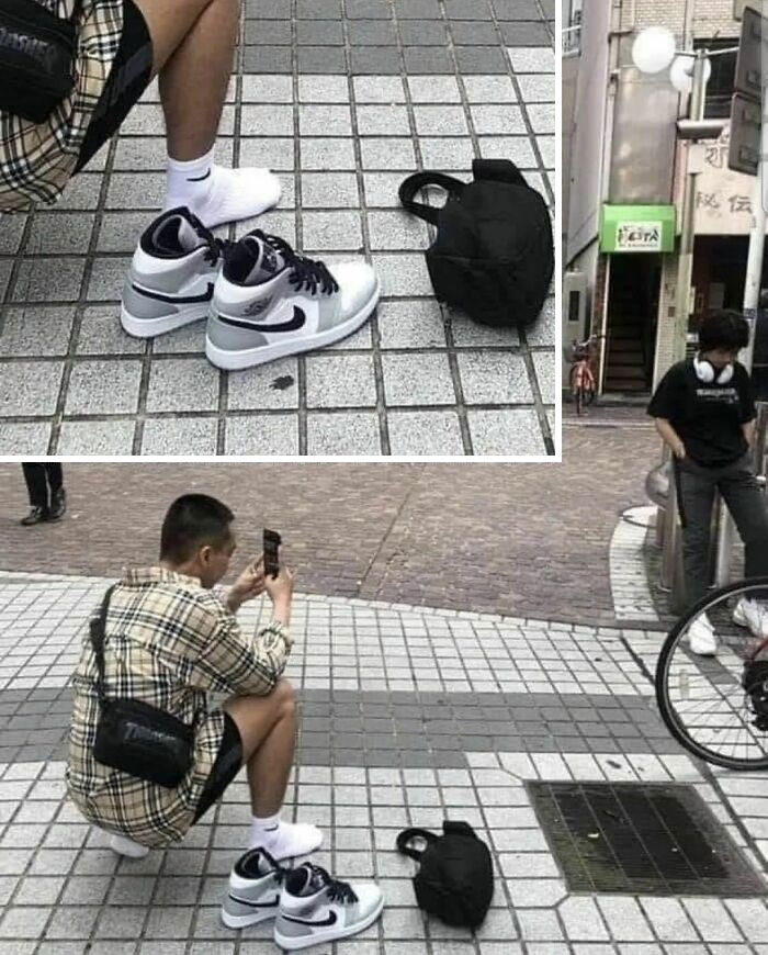 Person photographing shoes on tiled street, depicting humans of capitalism.