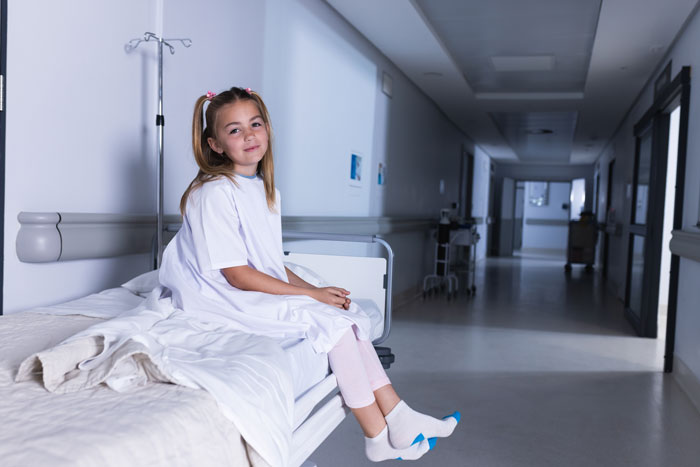 Young girl in a hospital corridor, highlighting daughter responsibility.