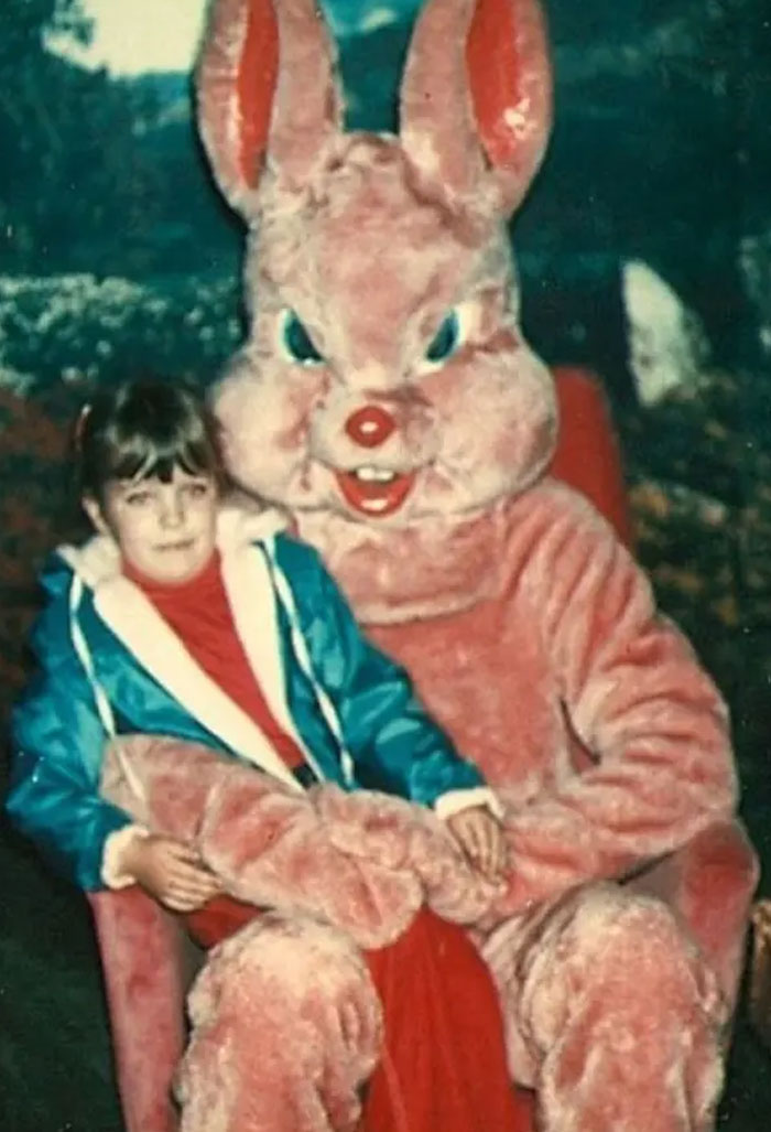 Child sitting on a giant pink bunny, evoking nostalgic memories from childhood.