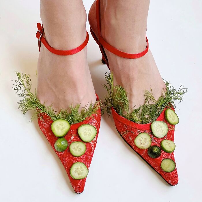 Sculptural footwear made from red heels adorned with cucumber slices and dill.