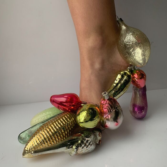 Sculptural footwear crafted from colorful everyday objects, adorning a foot.