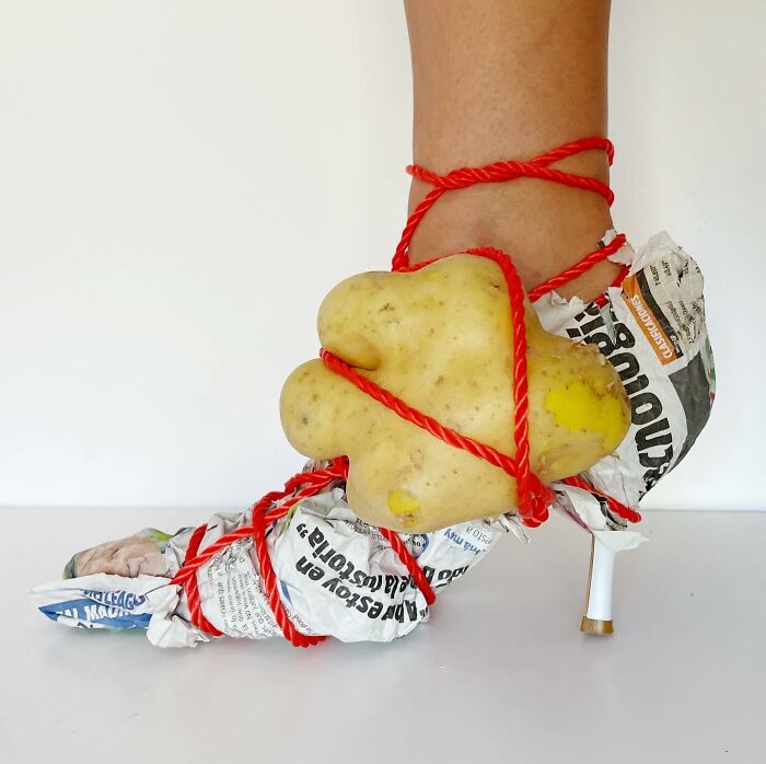 Sculptural footwear made from a potato, newspaper, and red rope, showcasing creative use of everyday objects.