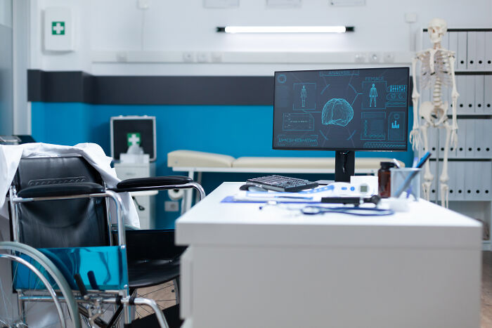 A clinical office with a wheelchair and medical equipment.