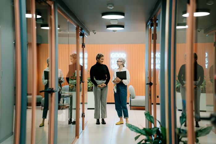 Two people in a modern office hallway.