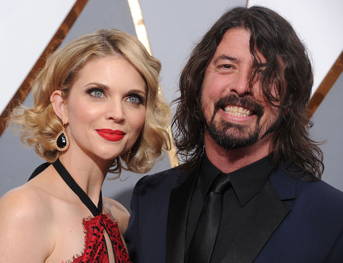 Jordyn Blum smiling with Dave Grohl, looking elegant at a formal event.