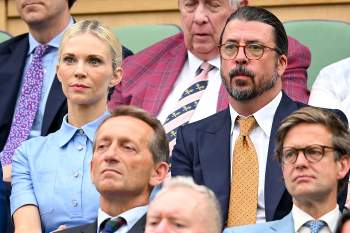 Jordyn Blum and Dave Grohl attending an event, seated among other attendees, focusing on the event proceedings.